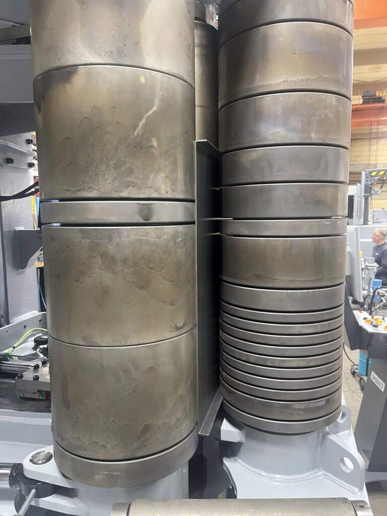 Close-up of profiled forming rolls on the SweBend SB3-105 CNC showing segmented roll geometry for flanged plate bending